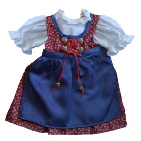 Das rote Puppendirndl hat eine blaue Schürze und weiße Puffärmel.