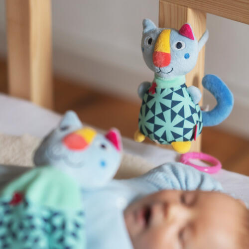 Die Mini-Spieluhr Katze ist an einem Babybettchen befestigt.