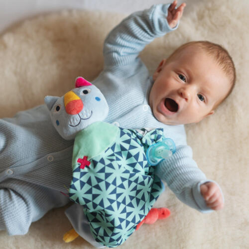 Ein Baby spielt mit dem Schmusetuch Katze Dluxe.