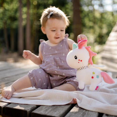 Ein Baby spielt mit der bezaubernden Spieluhr Einhorn.