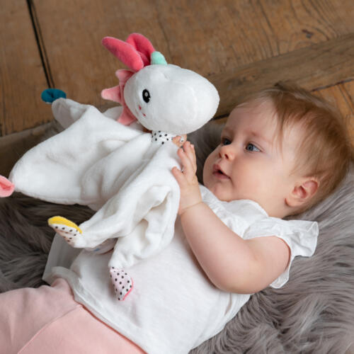 Ein Baby spielt mit dem Fehn Schmusetuch Einhorn.