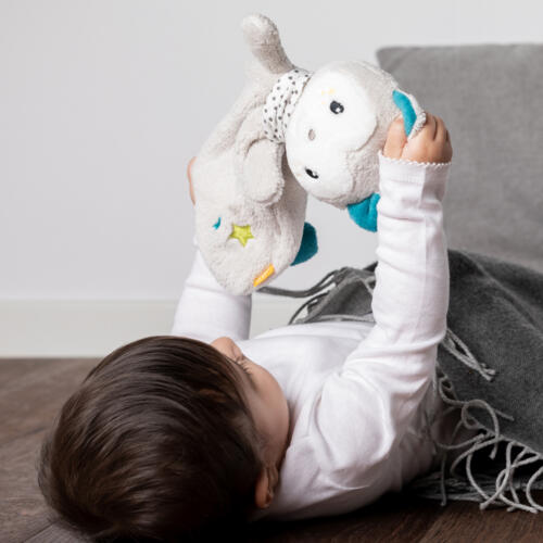 Ein Baby spielt mit dem Schmusetuch Katze von Fehn.