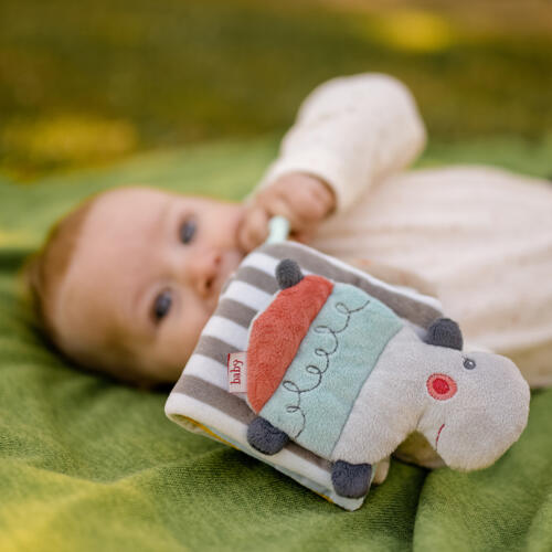 Ein Baby spielt mit dem Fehn Stoffbuch.