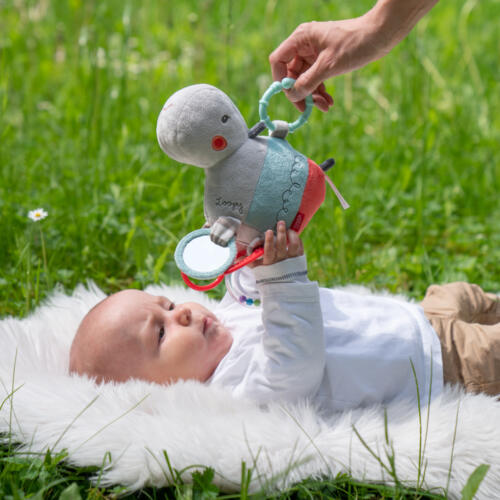 Ein Baby spielt mit dem Activity-Nilpferd.