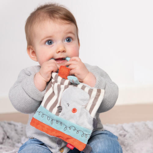 Ein Baby spielt mit dem Knistertuch Nilpferd.