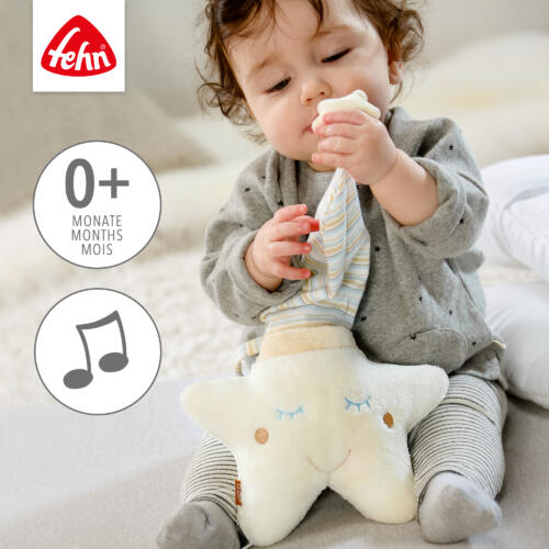 Ein Baby spielt mit der Spieluhr Stern.