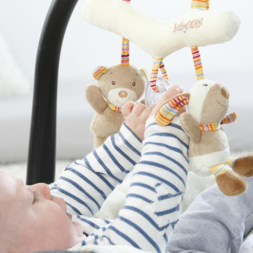 Ein Baby spielt mit dem Activity-Trapez Rainbow,