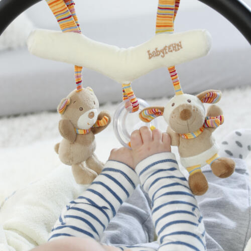 Ein Baby greift nach den Figuren des Activity Trapez.