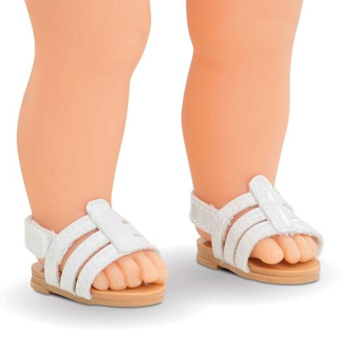 Eine Puppe trägt weiße Sandalen von Corolle
