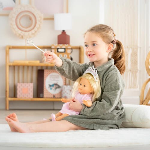 Ein Mädchen spielt mit ihrer Prinzessin Puppe.