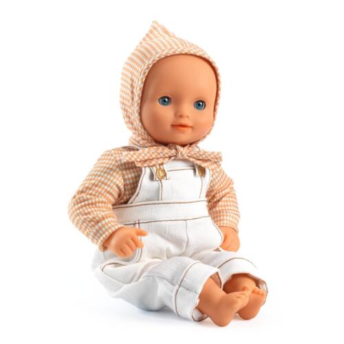 Eine Babypuppe trägt das süße Outfit Canelle, das aus Shirt, Latzhose und Babymütze besteht.