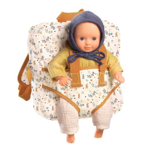 Eine Puppe sitzt im Rucksack mit Puppentrage.