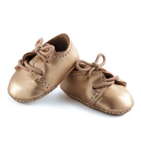 Die kleinen Puppenschuhe sind nur 4 cm groß. Das goldfarbene Leder ist mit feinen Nähten verarbeitet.