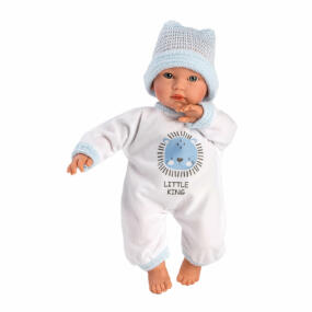 Die Puppe trägt einen weißen Overall und eine hellblaue Strickmütze. Der Overall ist mit einer blauen Applikation und blauen Bündchen verziert.