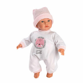 Die Puppe trägt einen weißen Overall und eine rosa Strickmütze. Der Overall ist mit einer rosafarbenen Applikation und rosa Bündchen verziert.