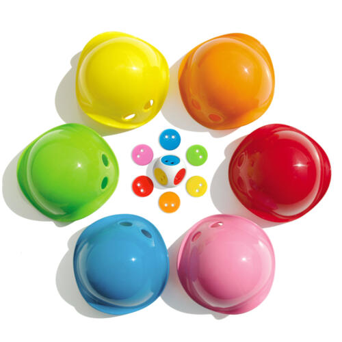 Die Bilibo Game Box enthält sechs bunte Mini Bilibo, einen Würfel und bunte Chips.