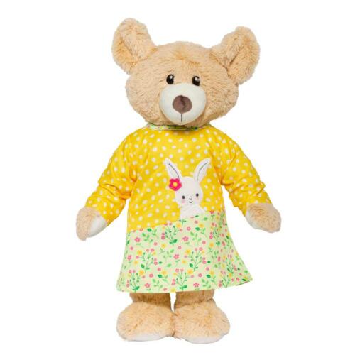 Ein Teddy trägt das hübsche Puppenkleid von Heless.