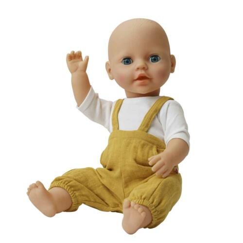 Eine Babypuppe trägt die gelbe Latzhose und das weiße Shirt.
