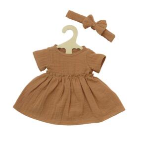 Das karamellfarbene Puppenkleid ist aus weichem Musselinstoff hergestellt.