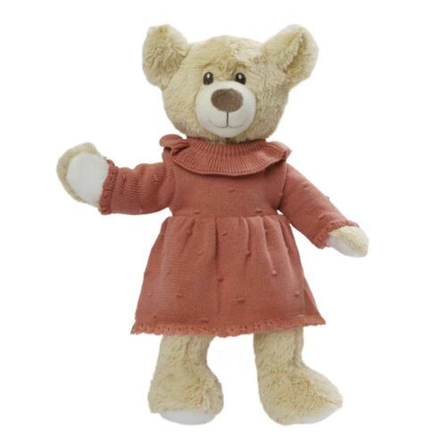 Ein Teddybär trägt das Strickkleidchen von Heless in der modischen Farbe Pfirsich..